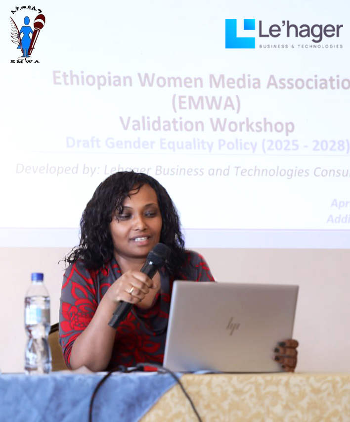 A presenter speaks into a microphone while using a laptop during the Ethiopian Women Media Association (EMWA) Validation Workshop for the Draft Gender Equality Policy (2025–2028). 